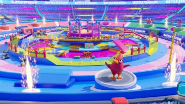 Close-up of battle stadium 3D model featuring a red bird character on platform with vibrant arena obstacles and pyrotechnic effects